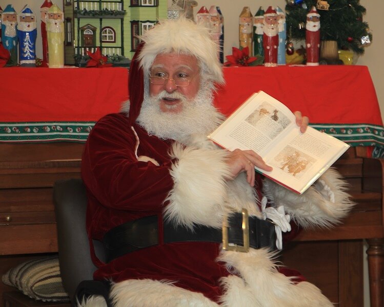 Bob Twaits dressed as santa reading book